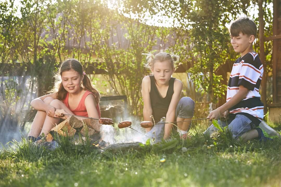 Des enfants profitent du feu en camping sauvage